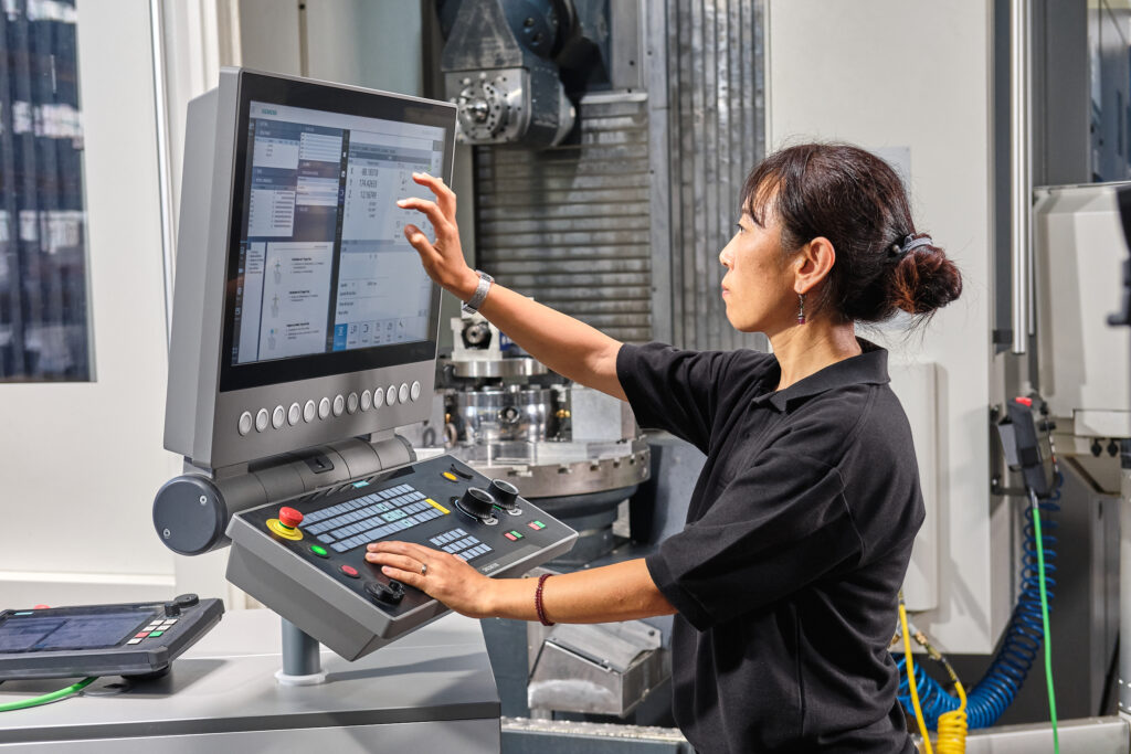 Moving to digital workflows and centralized data through paperless manufacturing 3 Female engineer uses Sinumerik machine